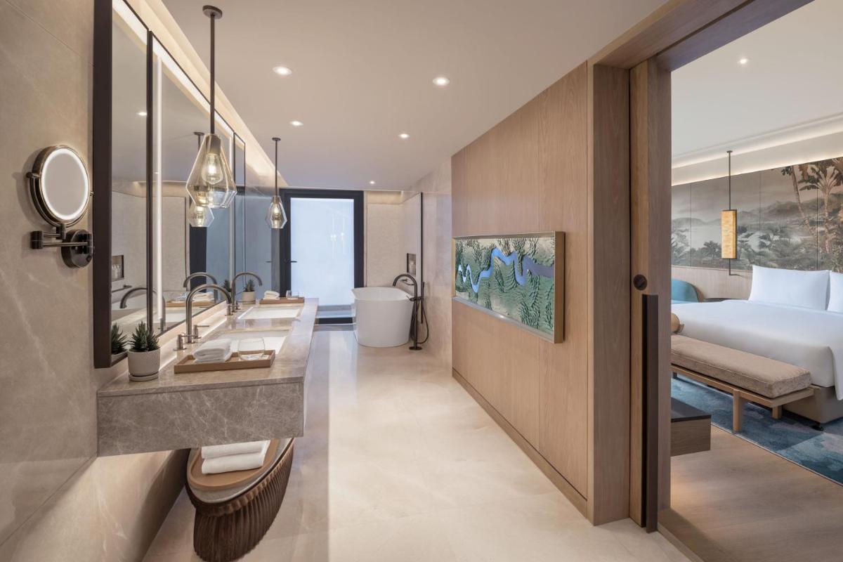 a hotel room with a bed and a bathroom at JW Marriott Goa in Vagator a hotel room with a bed and a bathroom at JW Marriott Goa in Vagator