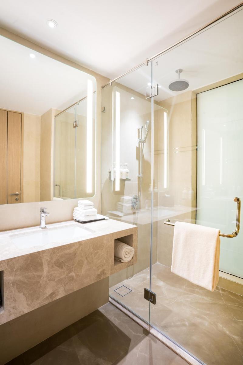 a bathroom with a sink and a glass shower at Holiday Inn Lucknow Airport by IHG in Lucknow