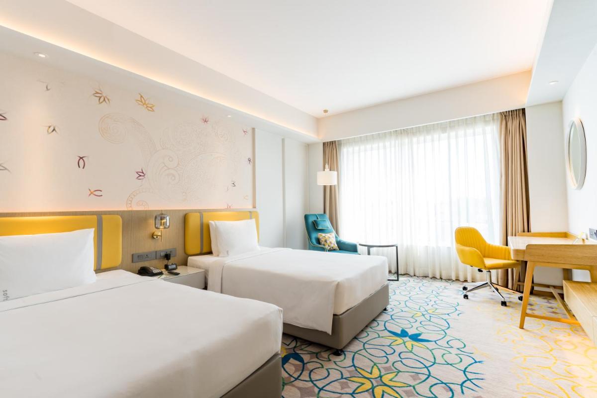 a hotel room with two beds and a desk at Holiday Inn Lucknow Airport by IHG in Lucknow