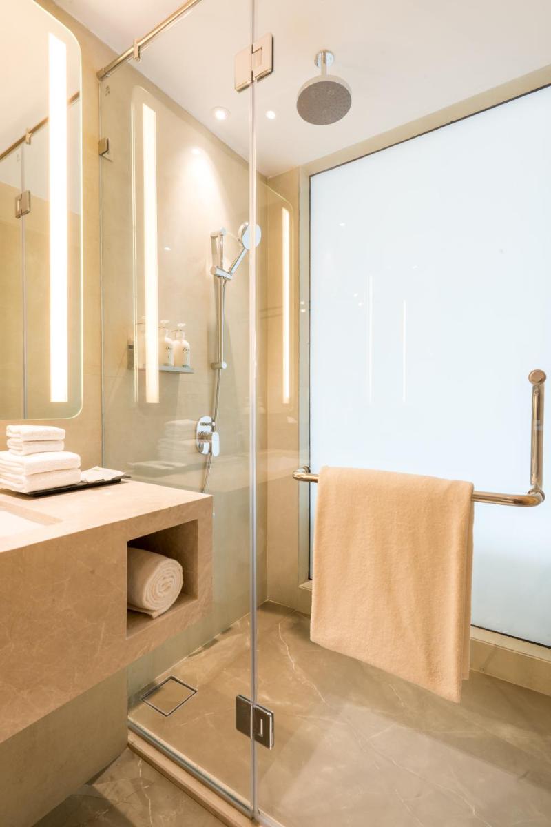 a bathroom with a shower with a glass door at Holiday Inn Lucknow Airport by IHG in Lucknow