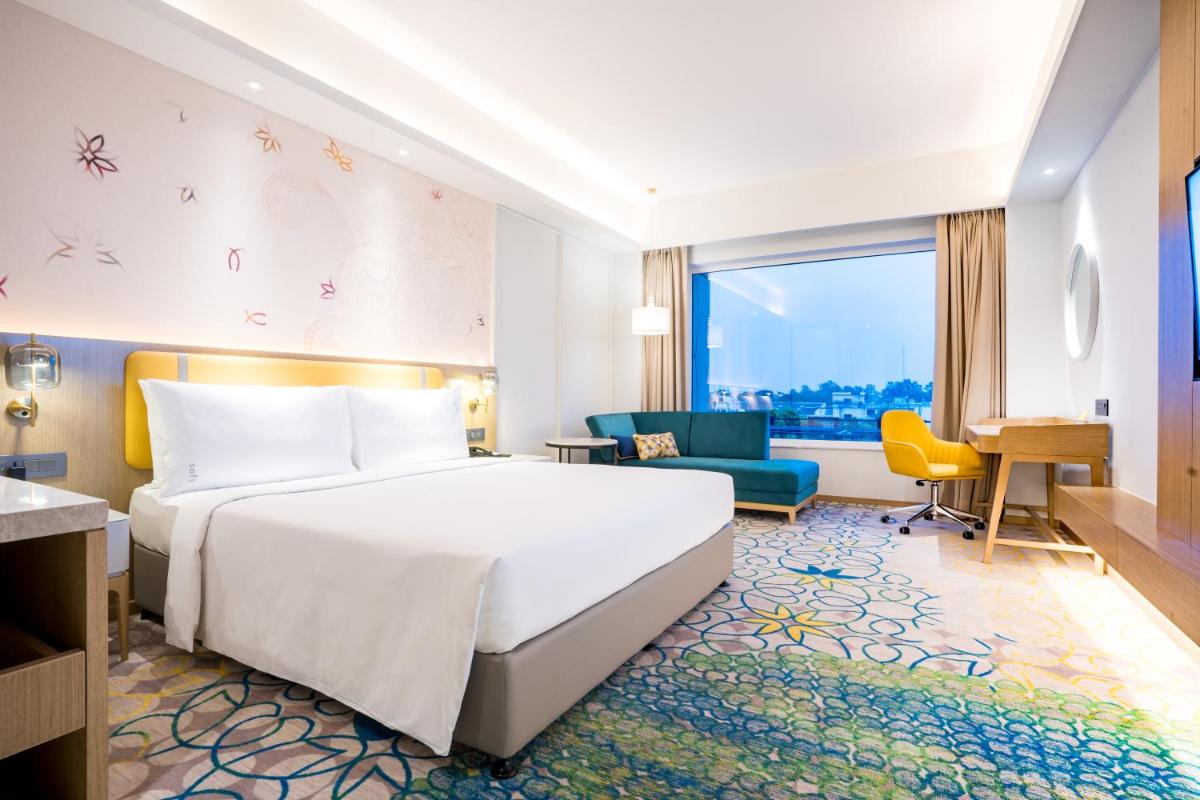 a hotel room with a bed and a desk at Holiday Inn Lucknow Airport by IHG in Lucknow