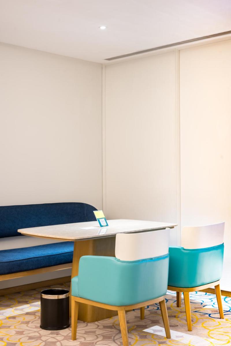 a room with a table and chairs and a bed at Holiday Inn Lucknow Airport by IHG in Lucknow