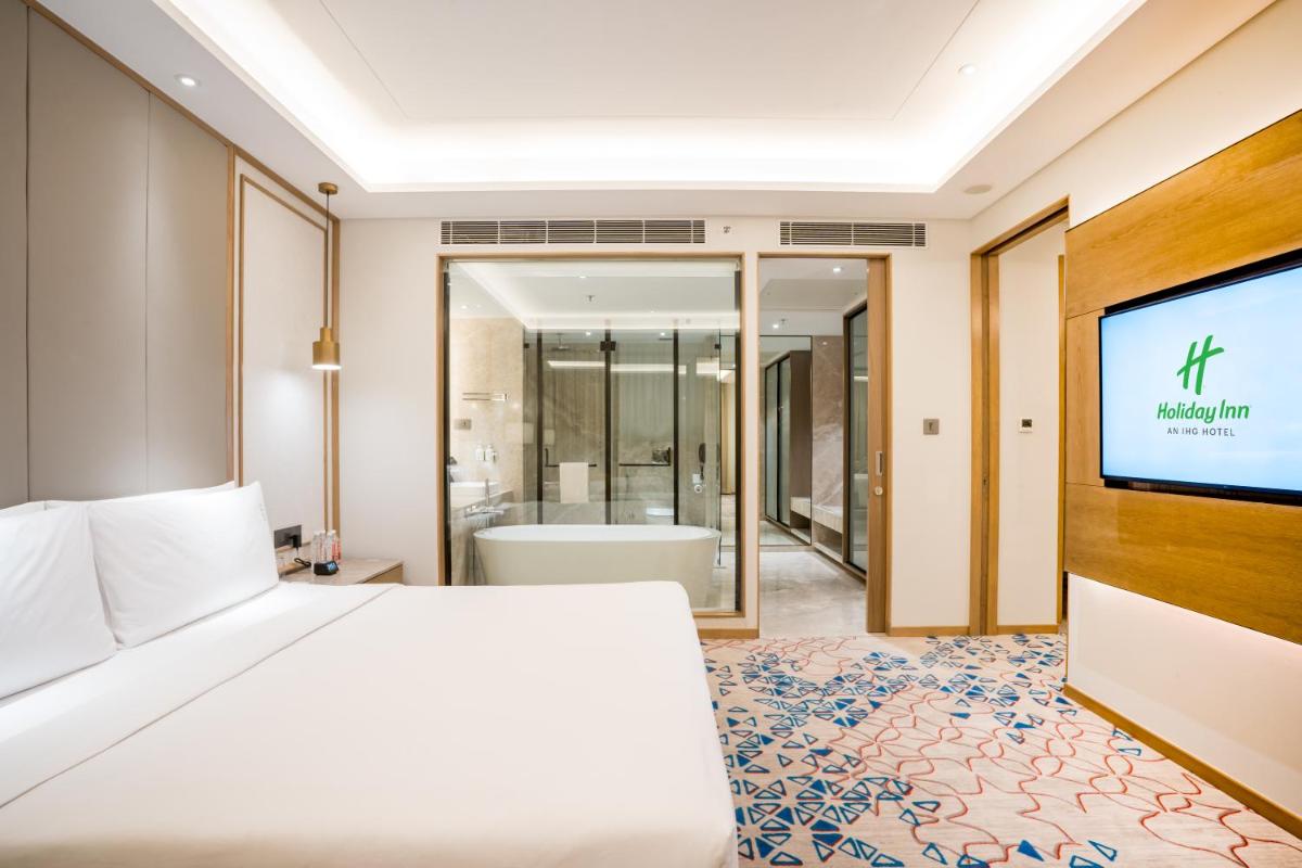 a bedroom with a bed and a flat screen tv at Holiday Inn Lucknow Airport by IHG in Lucknow