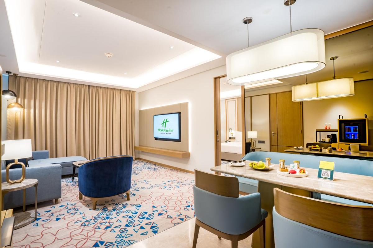 a hotel room with a dining area and a living room at Holiday Inn Lucknow Airport by IHG in Lucknow
