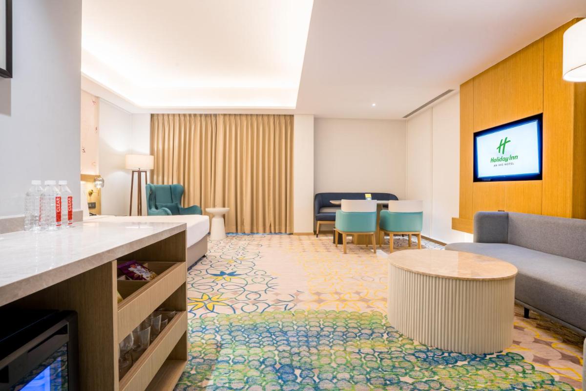 a living room with a couch and a table at Holiday Inn Lucknow Airport by IHG in Lucknow