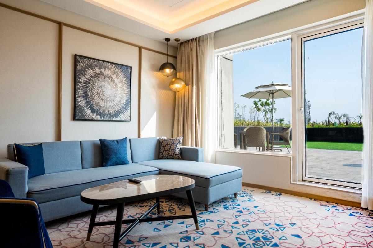 a living room with a blue couch and a table at Holiday Inn Lucknow Airport by IHG in Lucknow