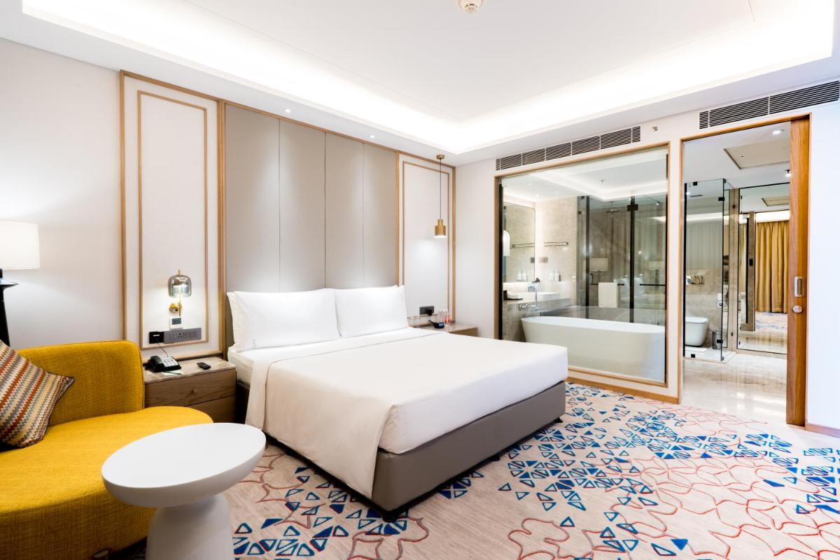 a hotel room with a bed and a bath tub at Holiday Inn Lucknow Airport by IHG in Lucknow