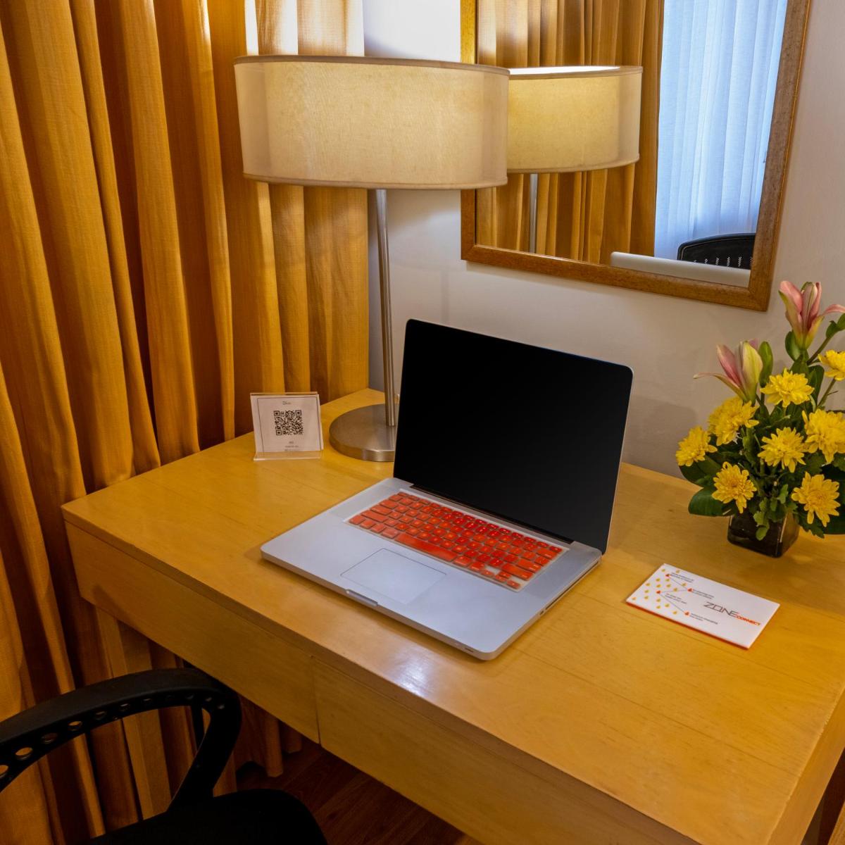 a laptop computer sitting on a desk in a hotel room at Zone Connect by The Park Saket New Delhi in New Delhi a laptop computer sitting on a desk in a hotel room at Zone Connect by The Park Saket New Delhi in New Delhi