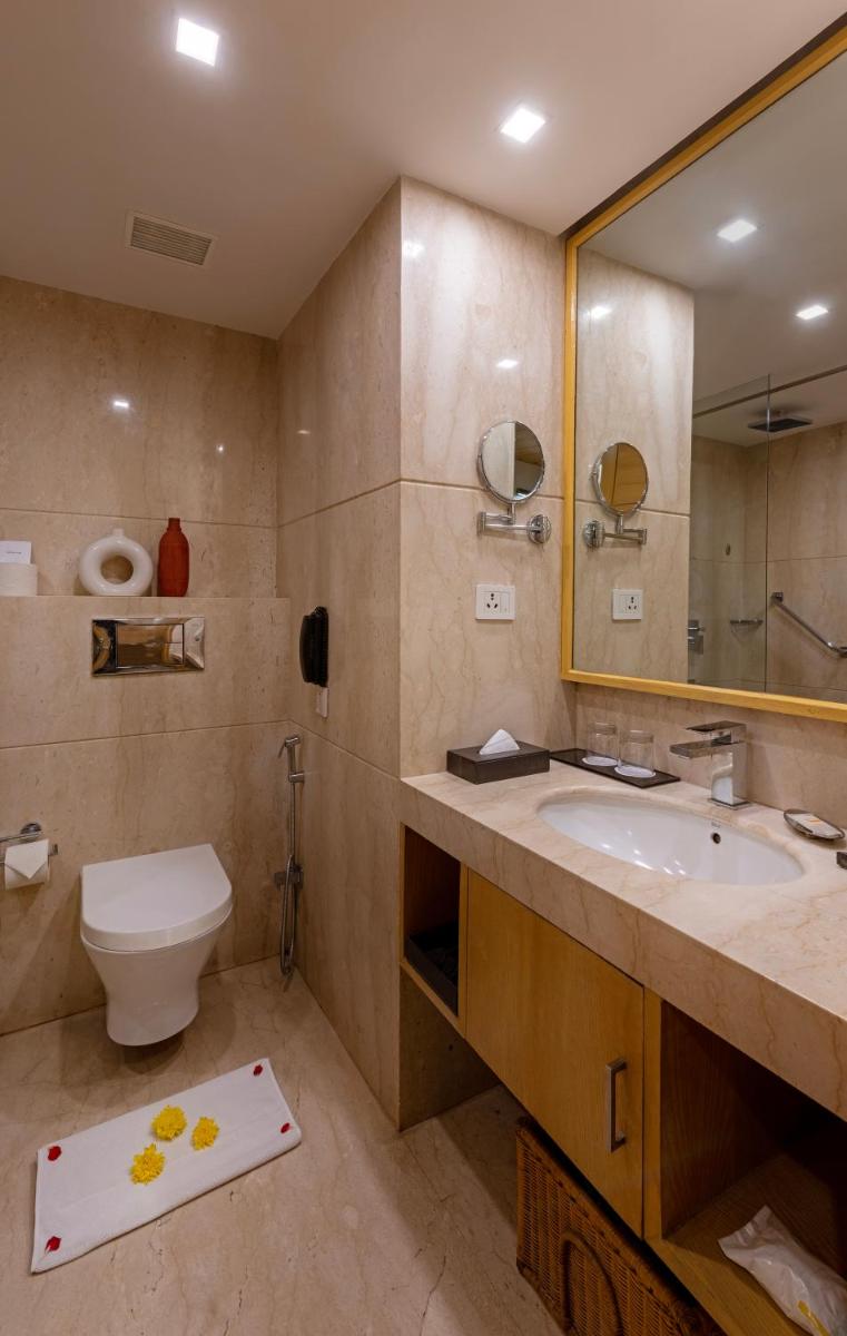 a bathroom with a sink and a toilet and a mirror at Zone Connect by The Park Saket New Delhi in New Delhi a bathroom with a sink and a toilet and a mirror at Zone Connect by The Park Saket New Delhi in New Delhi