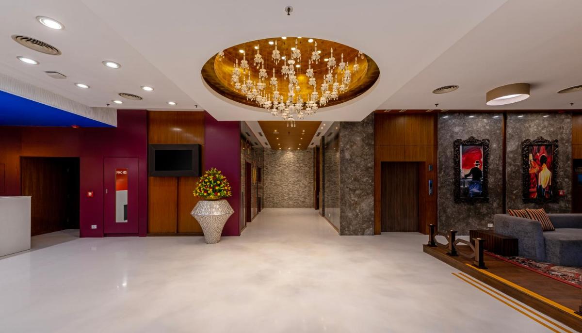 a lobby with a large chandelier and a couch at Zone Connect by The Park Saket New Delhi in New Delhi a lobby with a large chandelier and a couch at Zone Connect by The Park Saket New Delhi in New Delhi