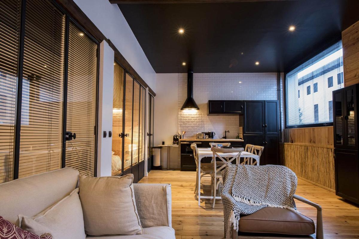 un salon avec un canapé et une table avec des chaises dans l'établissement Rock Noir & Spa, à La Salle Les Alpes