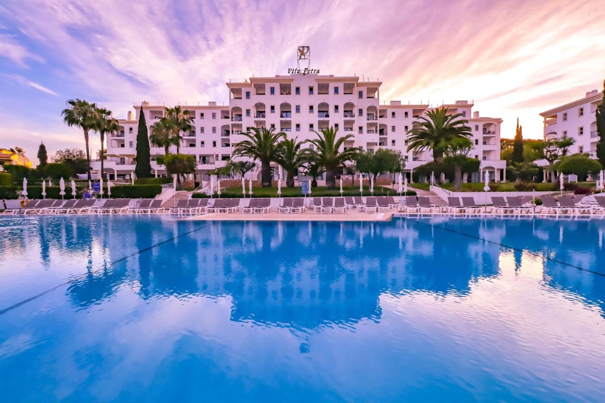 um hotel com uma grande piscina em frente em Vila Petra em Albufeira