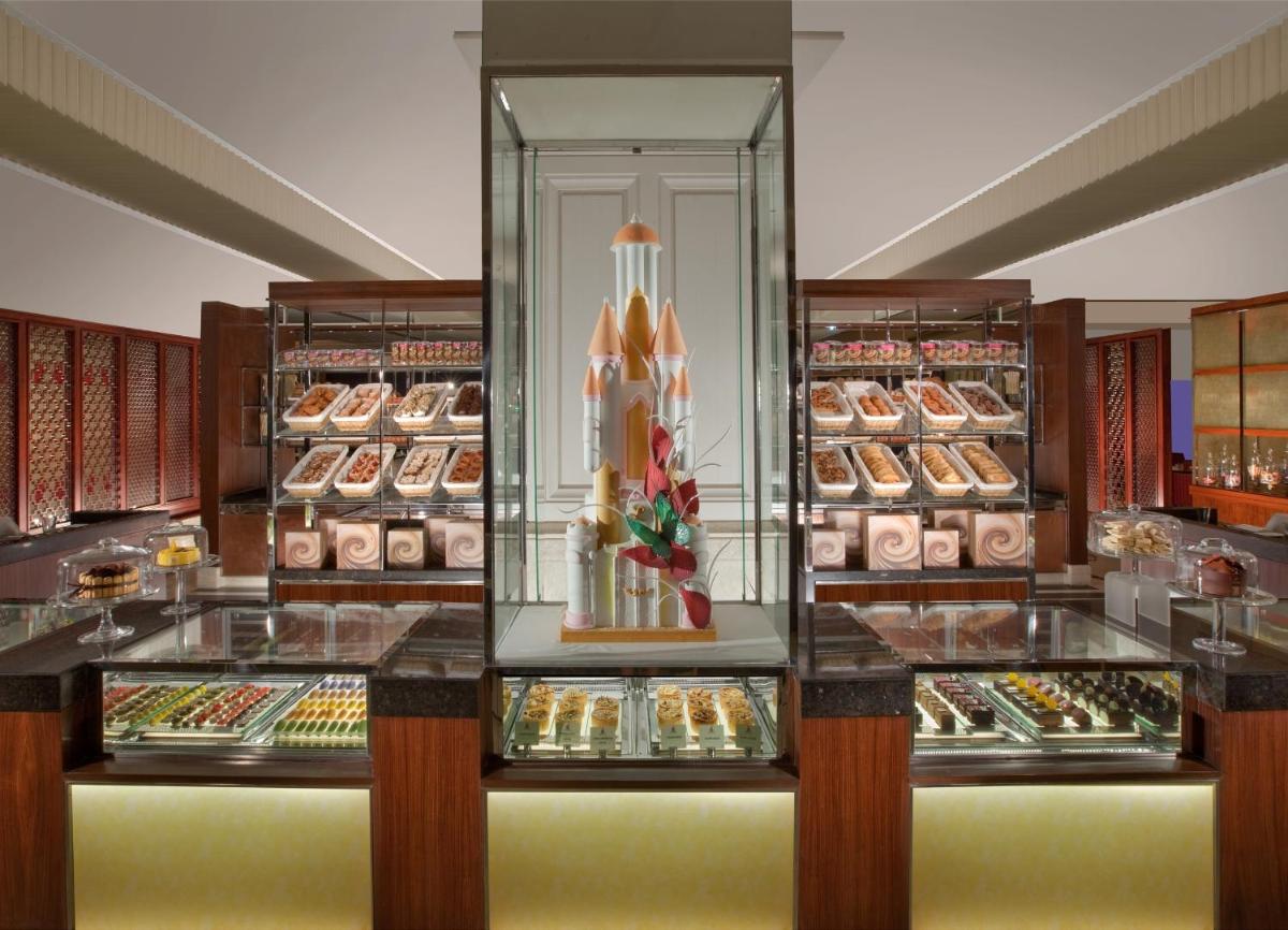 a display case in a bakery with many different pastries at The Leela Palace Chennai in Chennai a display case in a bakery with many different pastries at The Leela Palace Chennai in Chennai