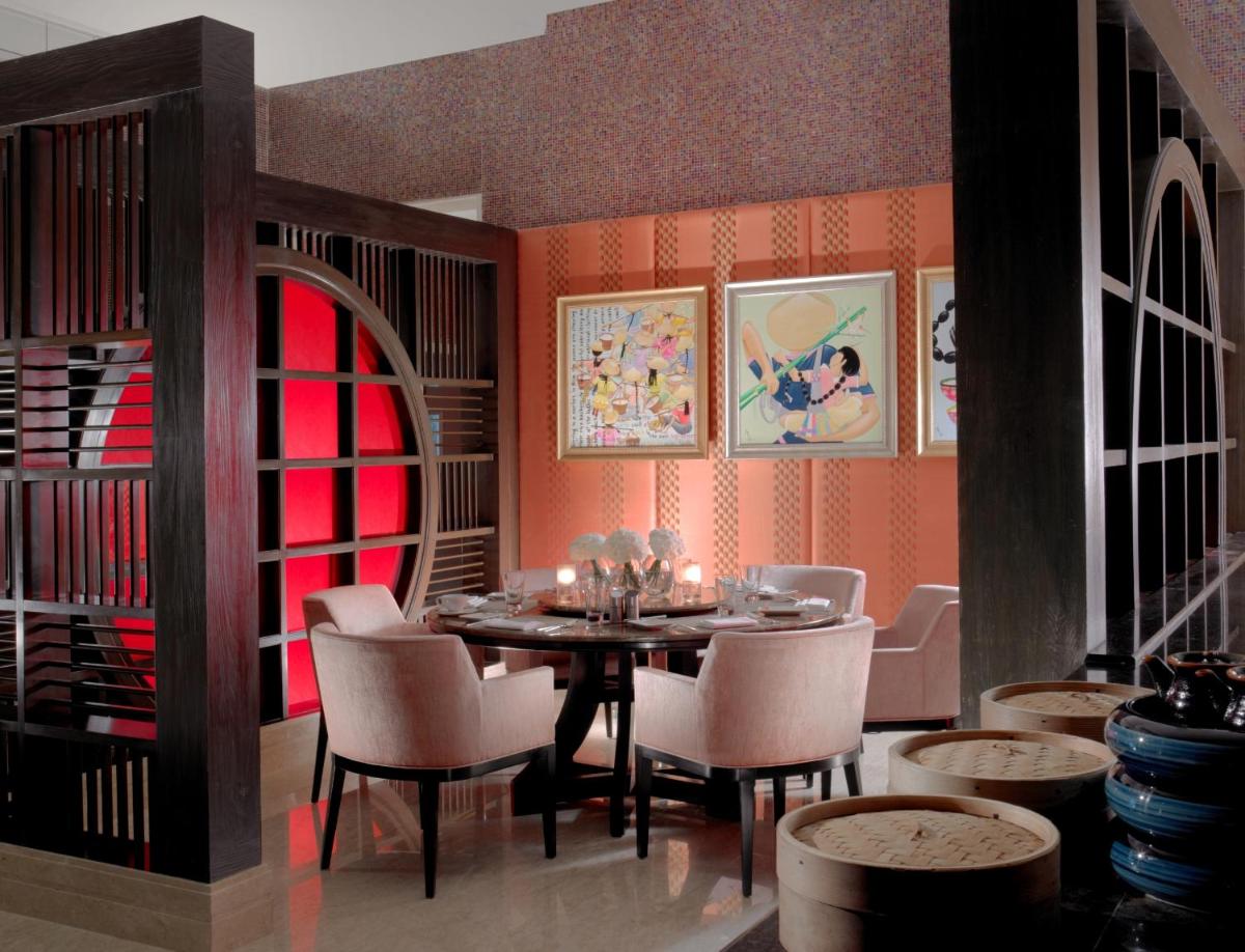 a dining room with a table and chairs at The Leela Palace Chennai in Chennai a dining room with a table and chairs at The Leela Palace Chennai in Chennai