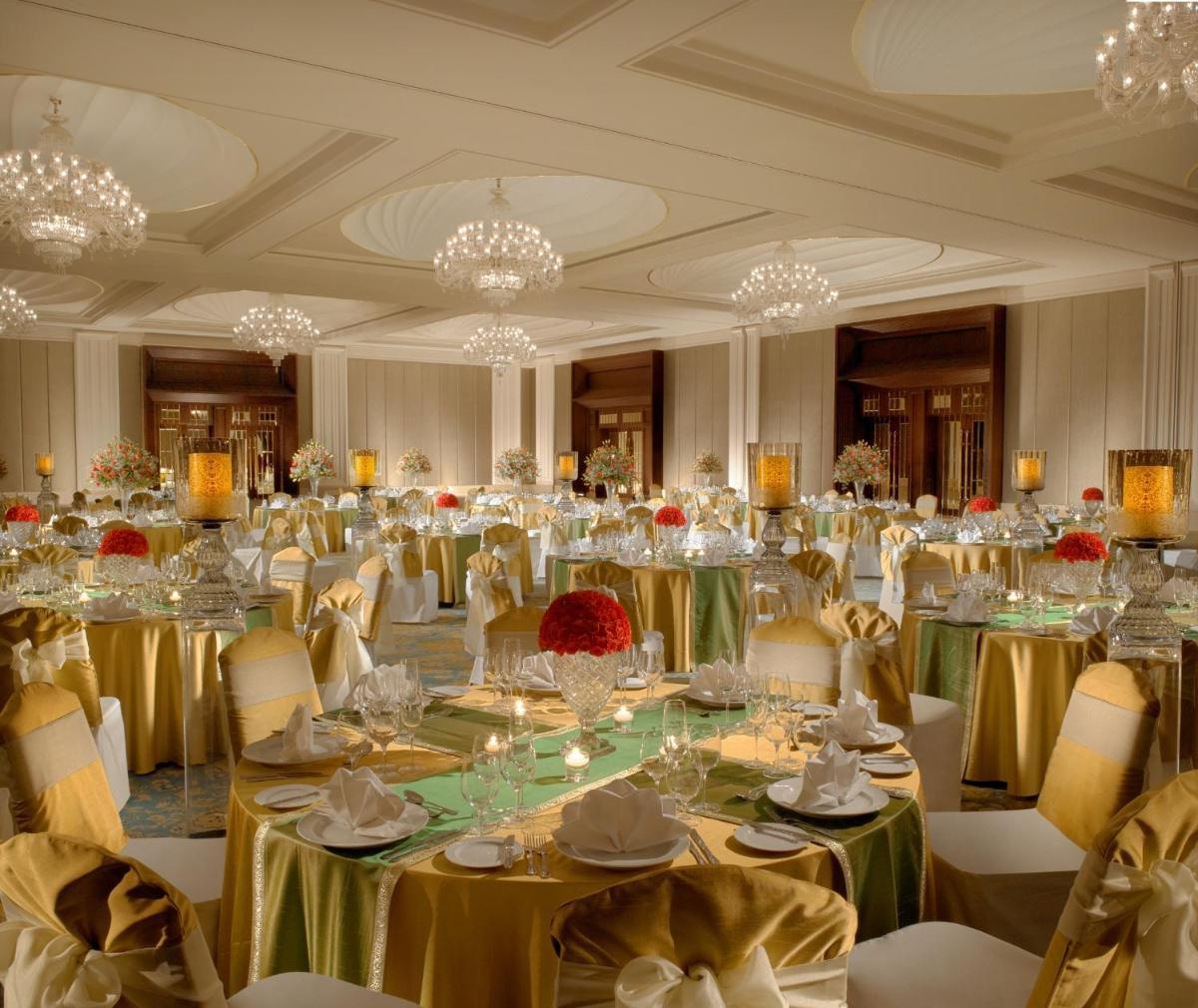 a large banquet room with tables and chairs and chandeliers at The Leela Palace Chennai in Chennai +66 photos a large banquet room with tables and chairs and chandeliers at The Leela Palace Chennai in Chennai +66 photos