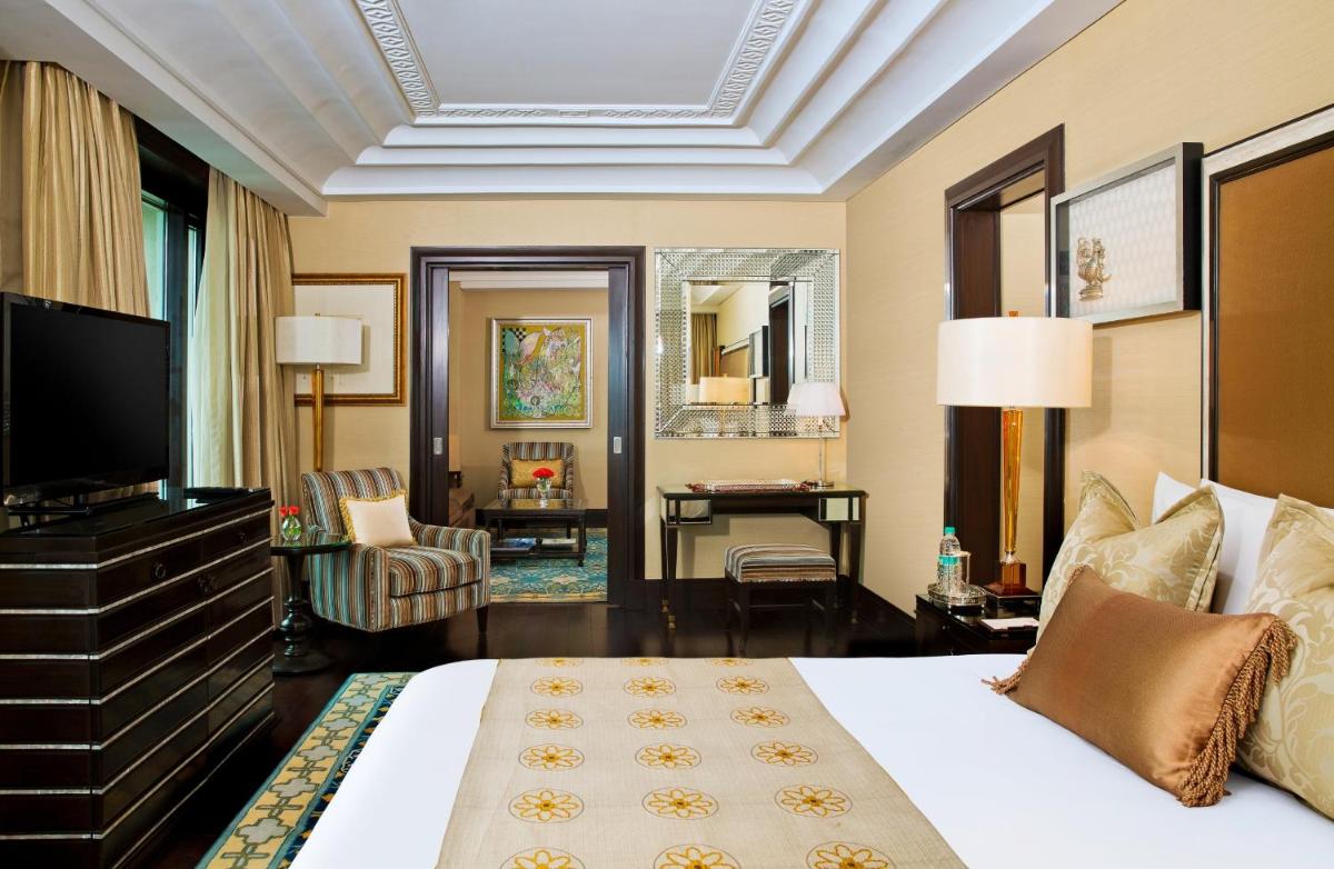 a hotel room with a bed and a television at The Leela Palace Chennai in Chennai a hotel room with a bed and a television at The Leela Palace Chennai in Chennai