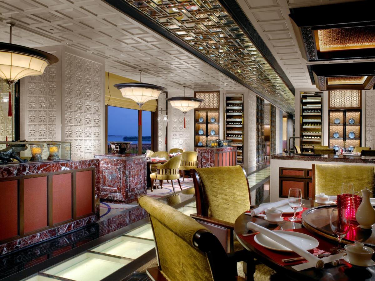 a dining room with a table and chairs at The Leela Palace Chennai in Chennai a dining room with a table and chairs at The Leela Palace Chennai in Chennai