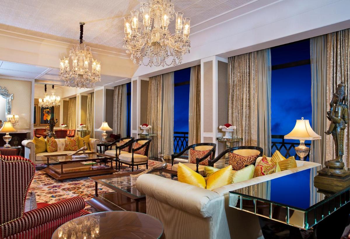 a hotel lobby with chandeliers and couches at The Leela Palace Chennai in Chennai a hotel lobby with chandeliers and couches at The Leela Palace Chennai in Chennai