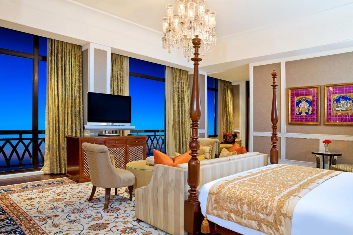a bedroom with a bed and a living room with a television at The Leela Palace Chennai in Chennai a bedroom with a bed and a living room with a television at The Leela Palace Chennai in Chennai