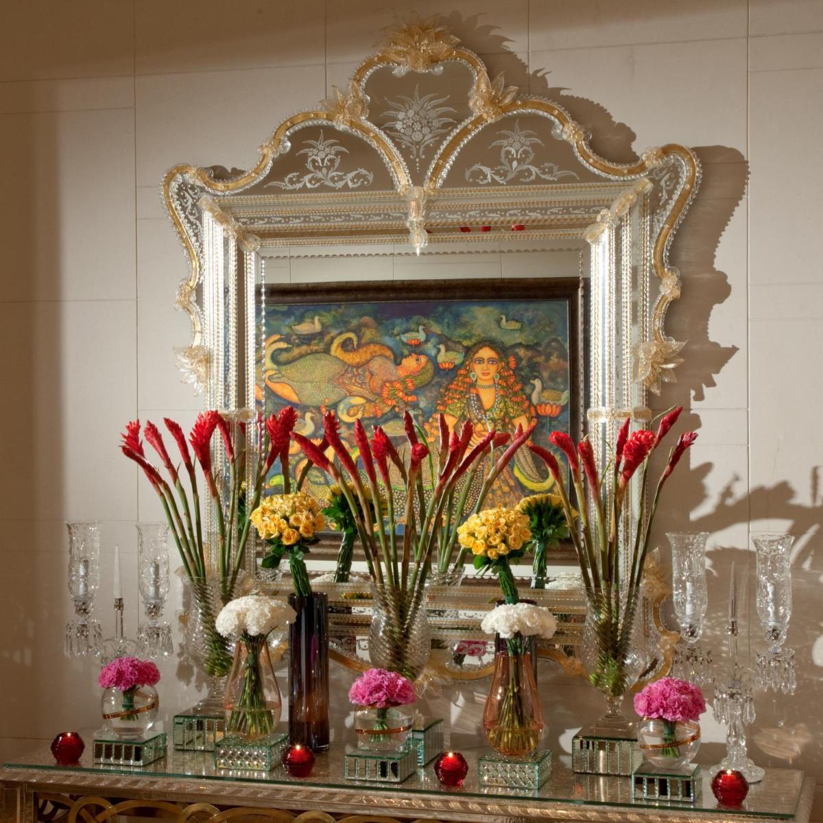 a group of vases with flowers on a table at The Leela Palace Chennai in Chennai a group of vases with flowers on a table at The Leela Palace Chennai in Chennai