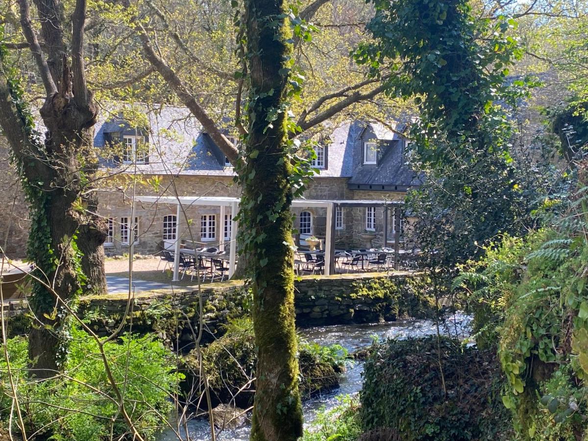 une maison avec une rivière devant elle dans l'établissement Les Moulins Du Duc ÉCOLODGE, à Moëlan-sur-Mer