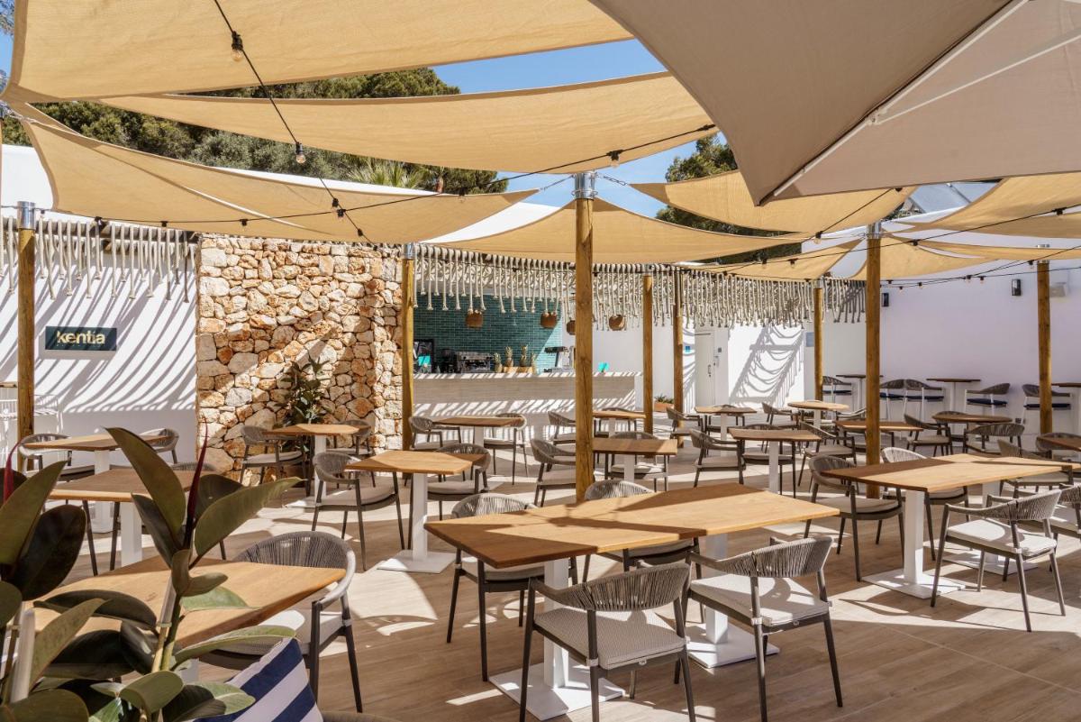 un restaurante con mesas y sillas bajo sombrillas en AluaSoul Mallorca Resort - Adults only, en Cala d´Or