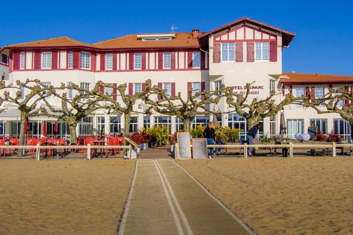 un grand bâtiment avec des arbres devant dans l'établissement Hôtel du Parc & Spa, à Hossegor