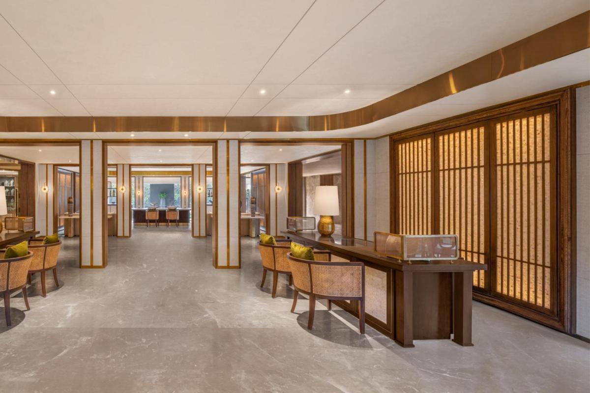 a lobby with a desk and chairs in a building at JW Marriott Goa in Vagator a lobby with a desk and chairs in a building at JW Marriott Goa in Vagator