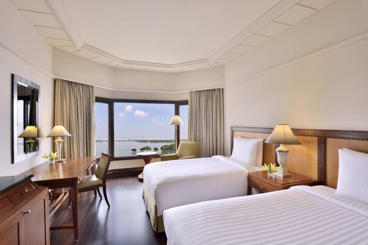 a hotel room with two beds and a desk at Hyderabad Marriott Hotel & Convention Centre in Hyderabad