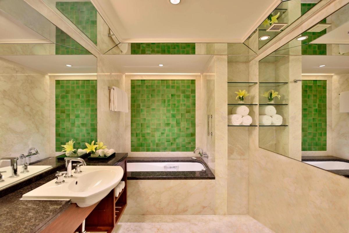 a bathroom with two sinks and a bath tub at Hyderabad Marriott Hotel & Convention Centre in Hyderabad