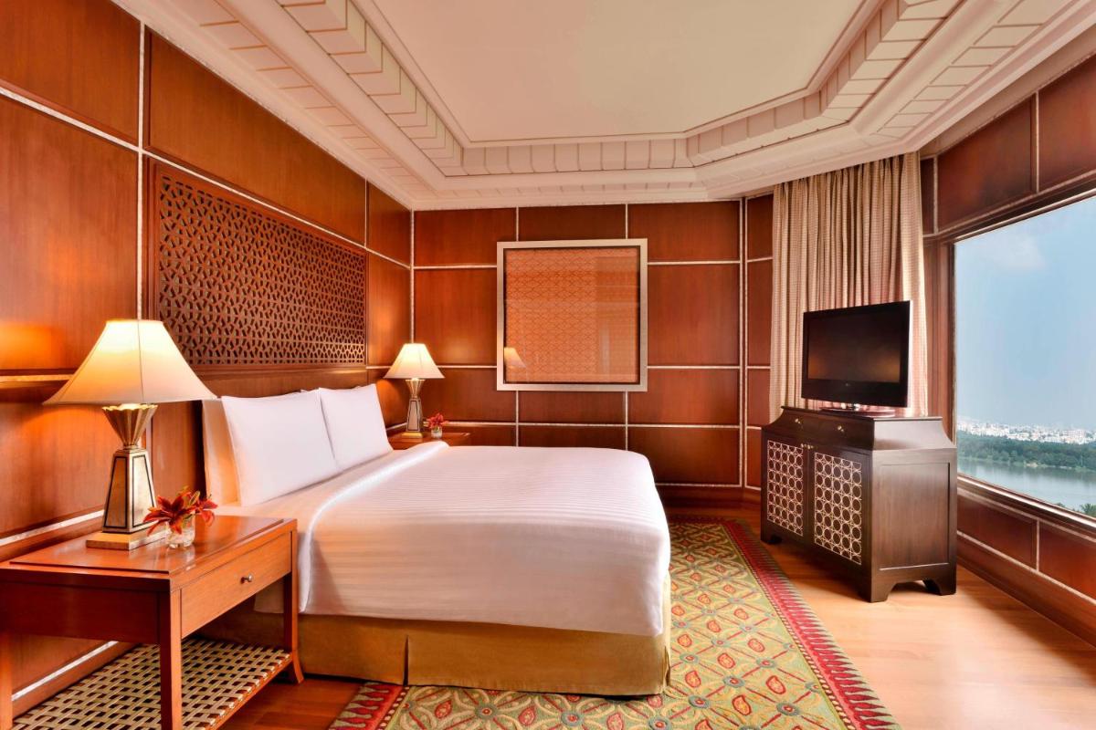a bedroom with a bed and a desk and a television at Hyderabad Marriott Hotel & Convention Centre in Hyderabad