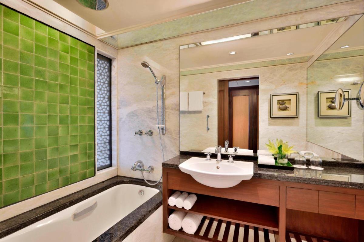 a bathroom with a sink and a bath tub and a sink at Hyderabad Marriott Hotel & Convention Centre in Hyderabad