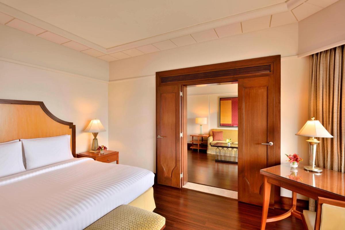 a hotel room with a bed and a desk and a bedroom at Hyderabad Marriott Hotel & Convention Centre in Hyderabad