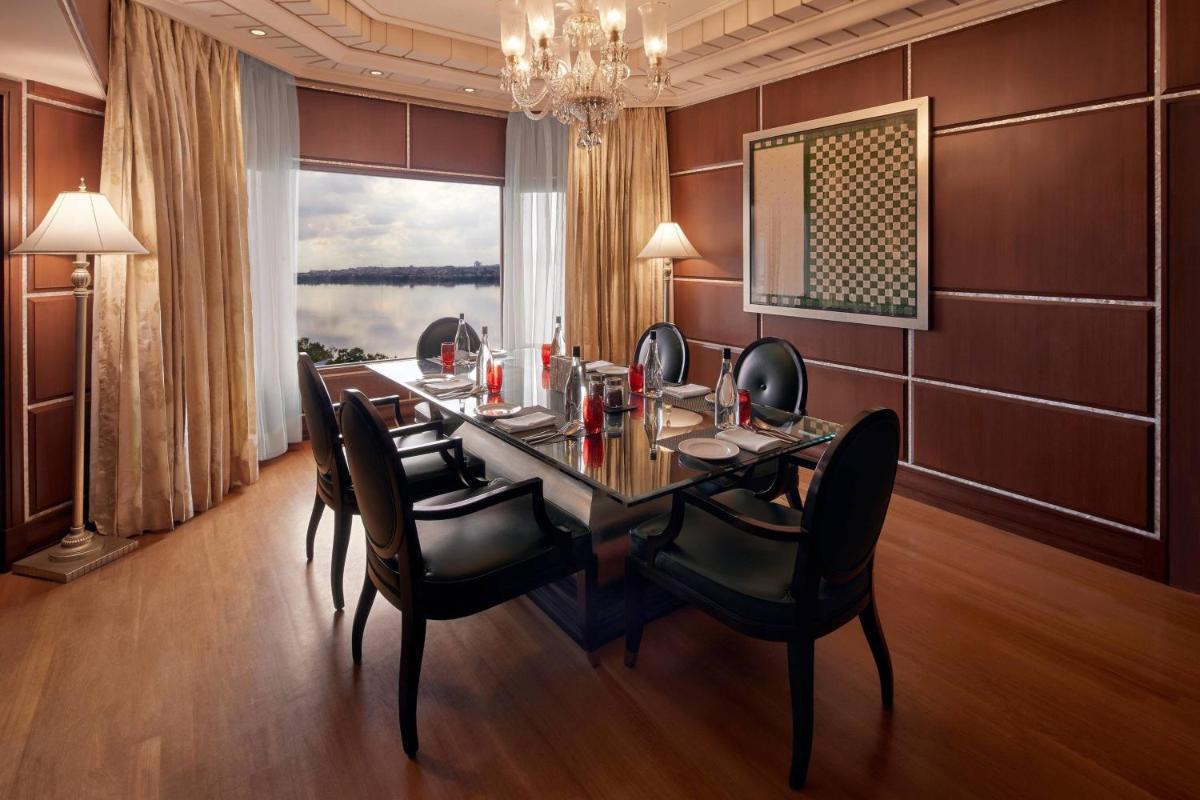 a dining room with a table and chairs and a window at Hyderabad Marriott Hotel & Convention Centre in Hyderabad