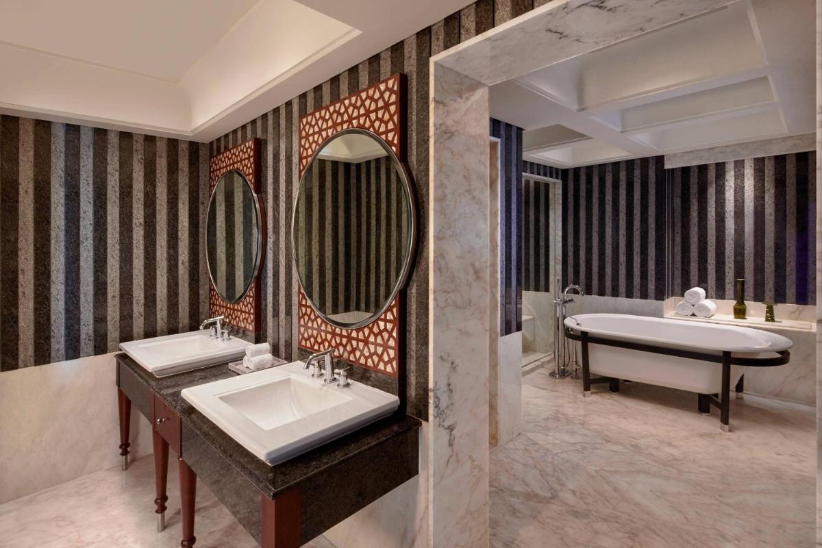 a bathroom with two sinks and a tub and mirror at Hyderabad Marriott Hotel & Convention Centre in Hyderabad a bathroom with two sinks and a tub and mirror at Hyderabad Marriott Hotel & Convention Centre in Hyderabad