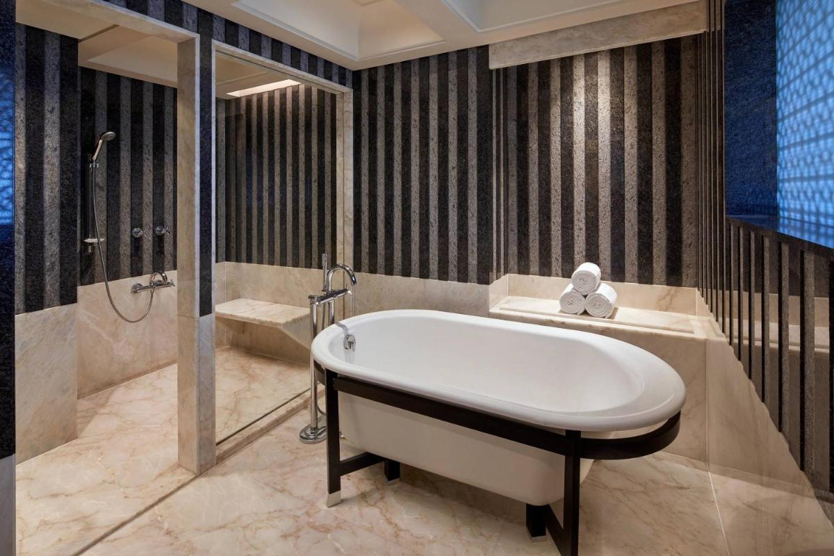 a bathroom with a tub and a shower at Hyderabad Marriott Hotel & Convention Centre in Hyderabad