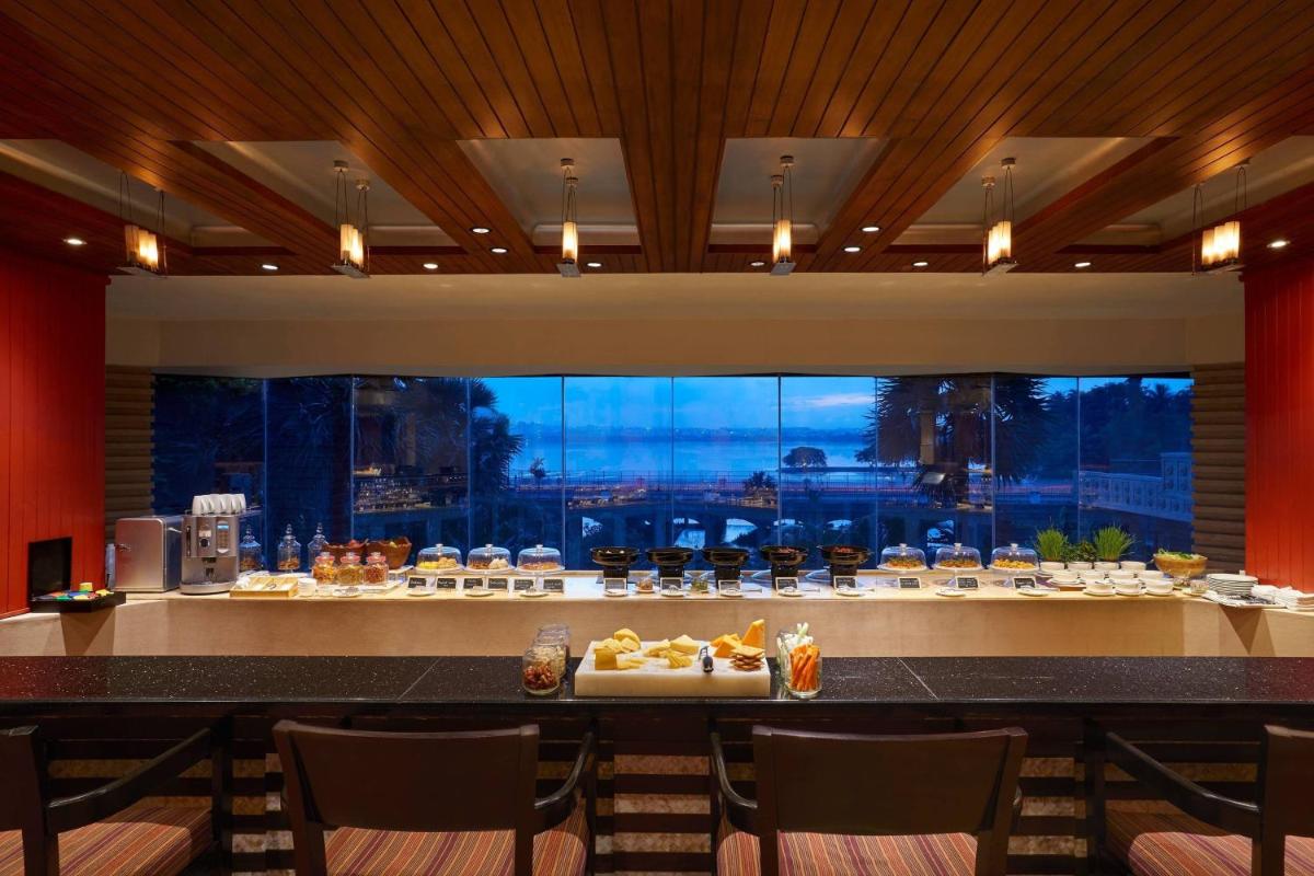 a restaurant with a buffet of food on a counter at Hyderabad Marriott Hotel & Convention Centre in Hyderabad
