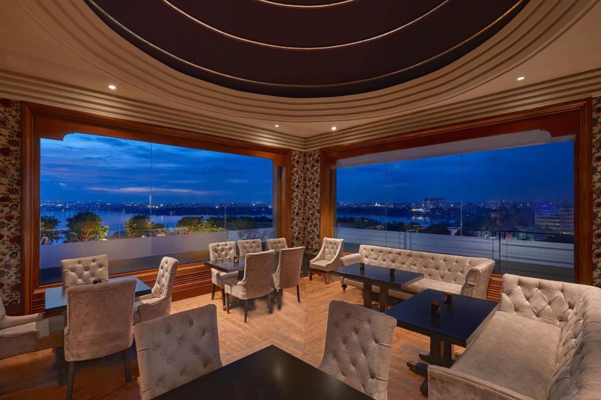 a room with chairs and tables and large windows at Hyderabad Marriott Hotel & Convention Centre in Hyderabad