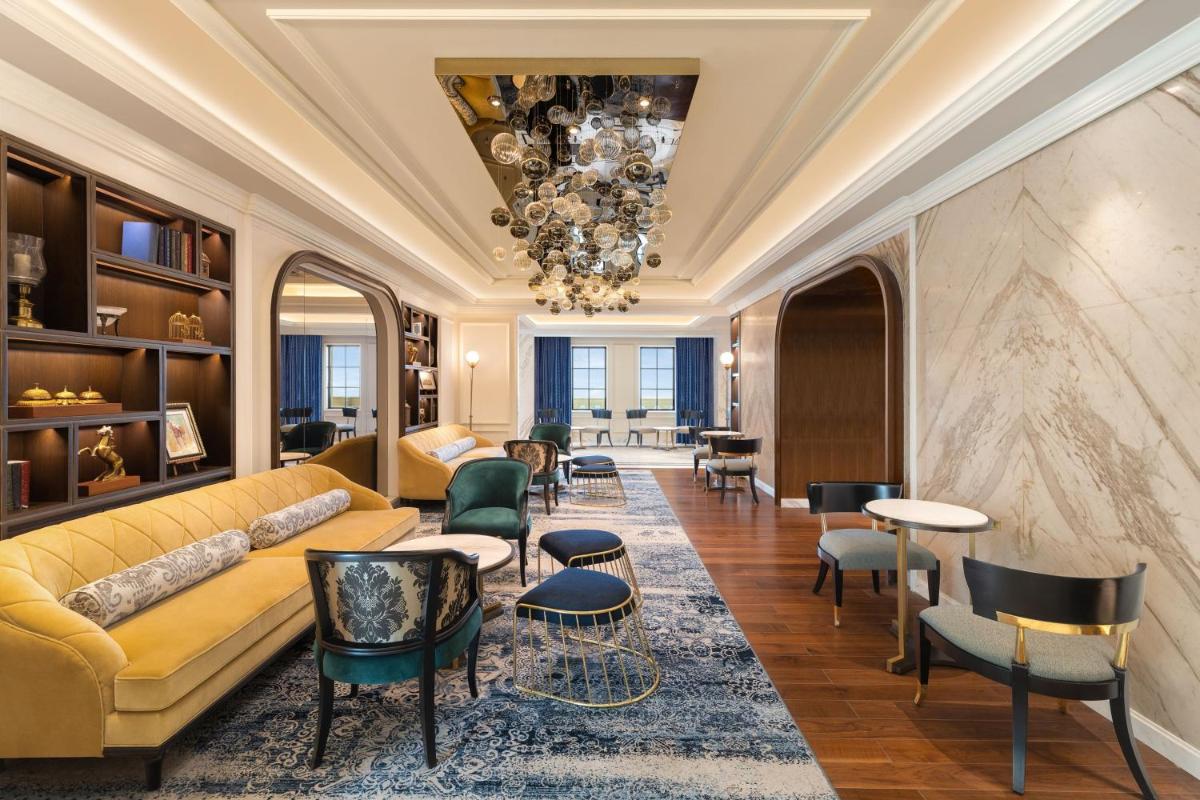 a living room with a yellow couch and chairs at ITC Royal Bengal, a Luxury Collection Hotel, Kolkata in Kolkata