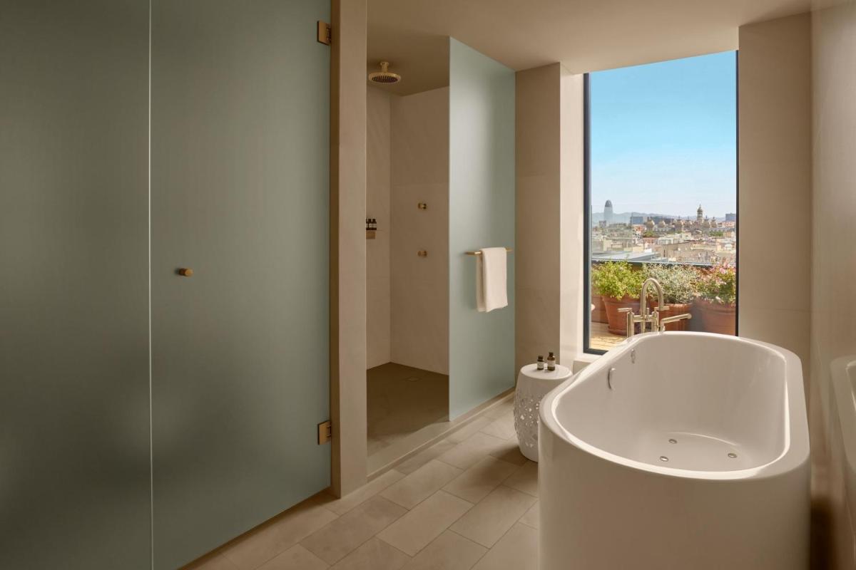 Un baño con bañera y una gran ventana. en The Barcelona EDITION, en Barcelona