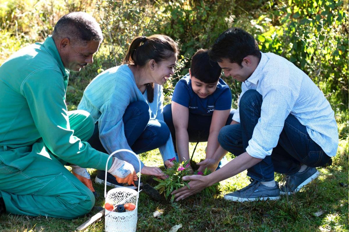a group of people planting flowers in a garden at JW Marriott Mussoorie Walnut Grove Resort & Spa in Mussoorie