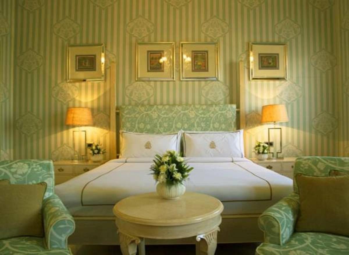 a bedroom with a bed and a table and chairs at Rajmahal Palace RAAS in Jaipur