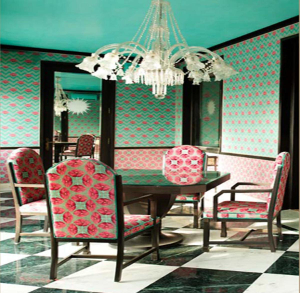 a dining room with a table and chairs and a chandelier at Rajmahal Palace RAAS in Jaipur