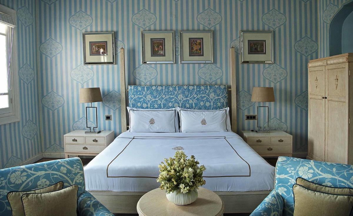 a bedroom with a bed with blue and white wallpaper at Rajmahal Palace RAAS in Jaipur