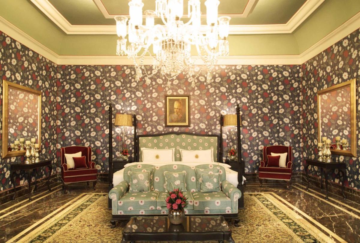 a bedroom with a bed and a chandelier at Rajmahal Palace RAAS in Jaipur