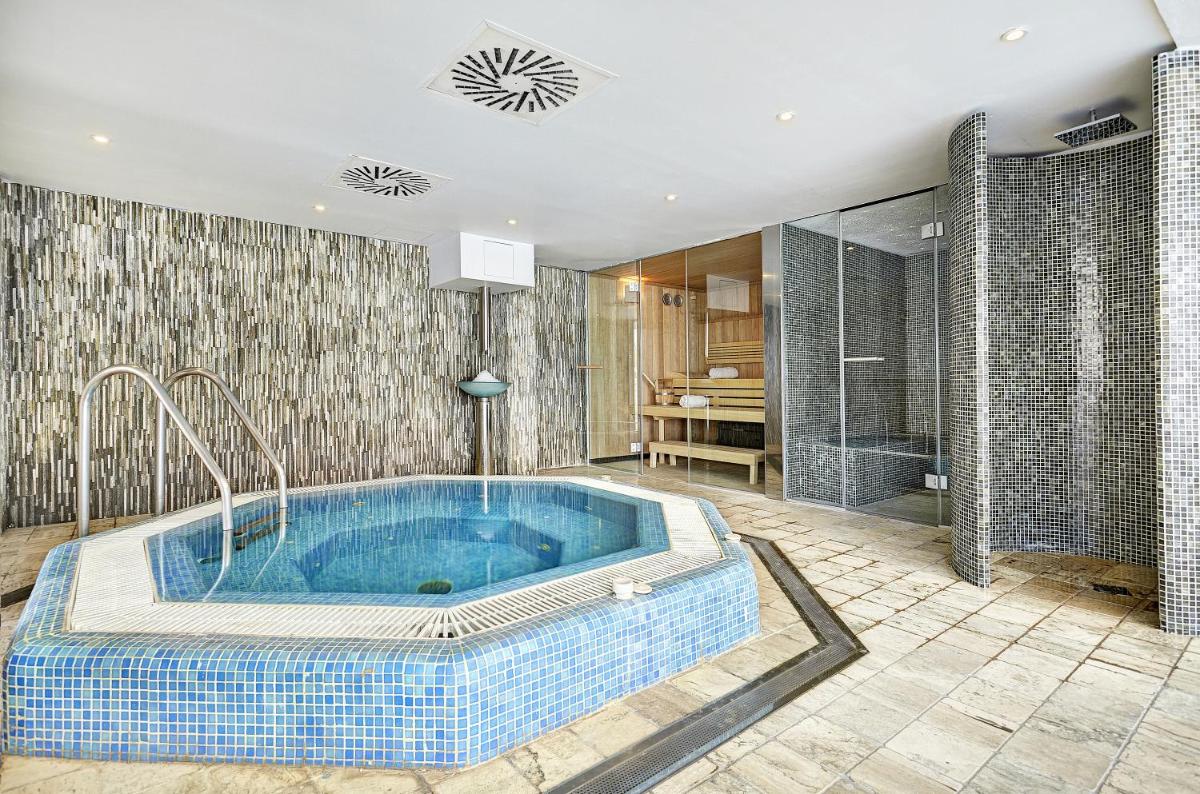 Un baño con una gran bañera azul en una habitación. en Grupotel Acapulco Playa - Adults Only, en Playa de Palma