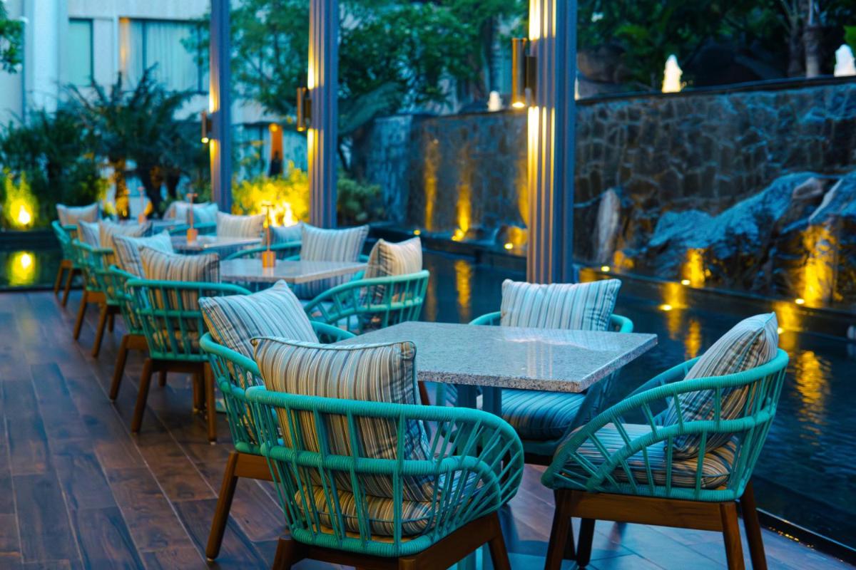 a row of tables and chairs on a patio at Hyatt Hyderabad Gachibowli in Hyderabad