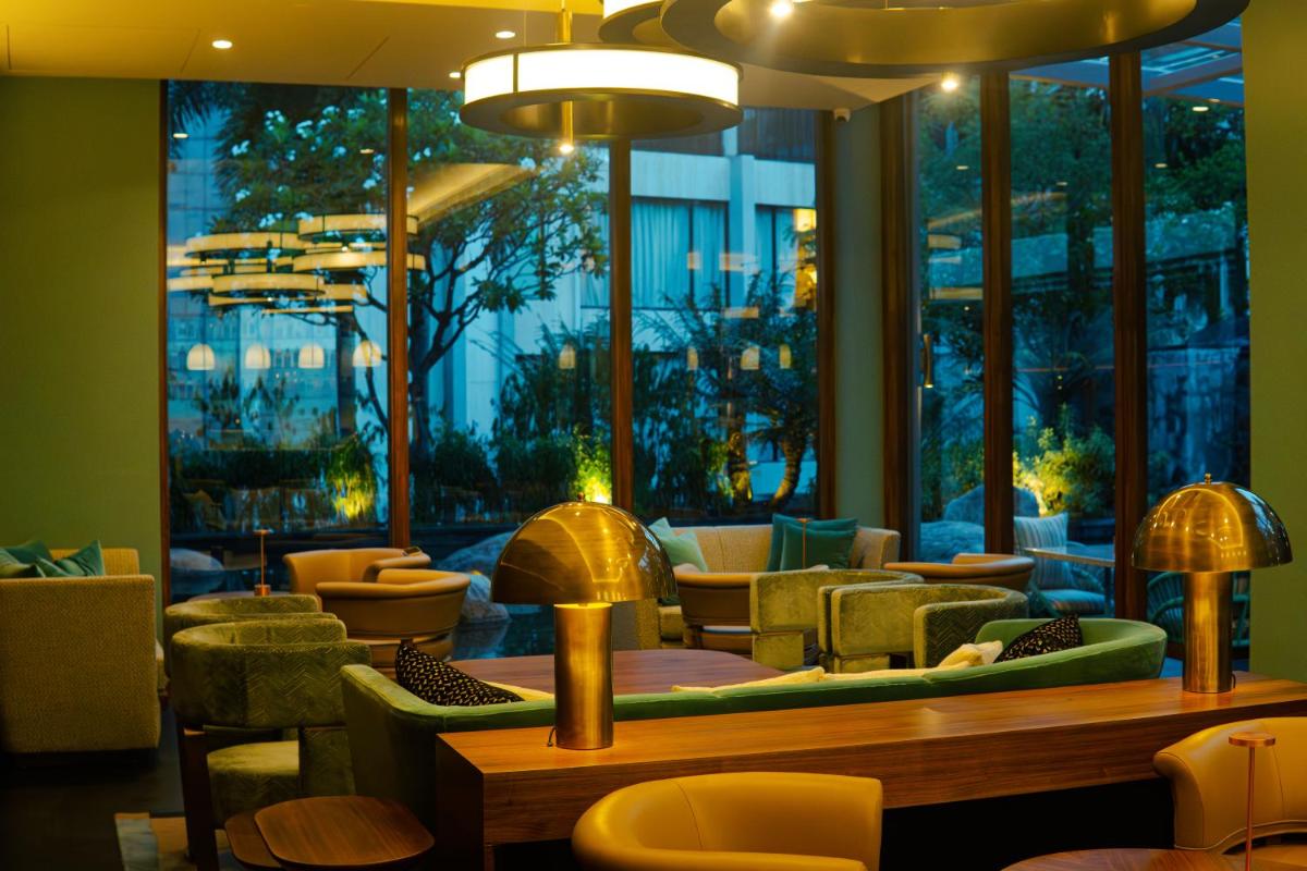 a restaurant with chairs and tables and a large window at Hyatt Hyderabad Gachibowli in Hyderabad