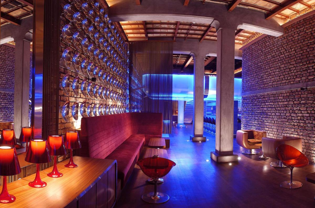 a bar with a couch and some wine glasses at The Park Kolkata in Kolkata