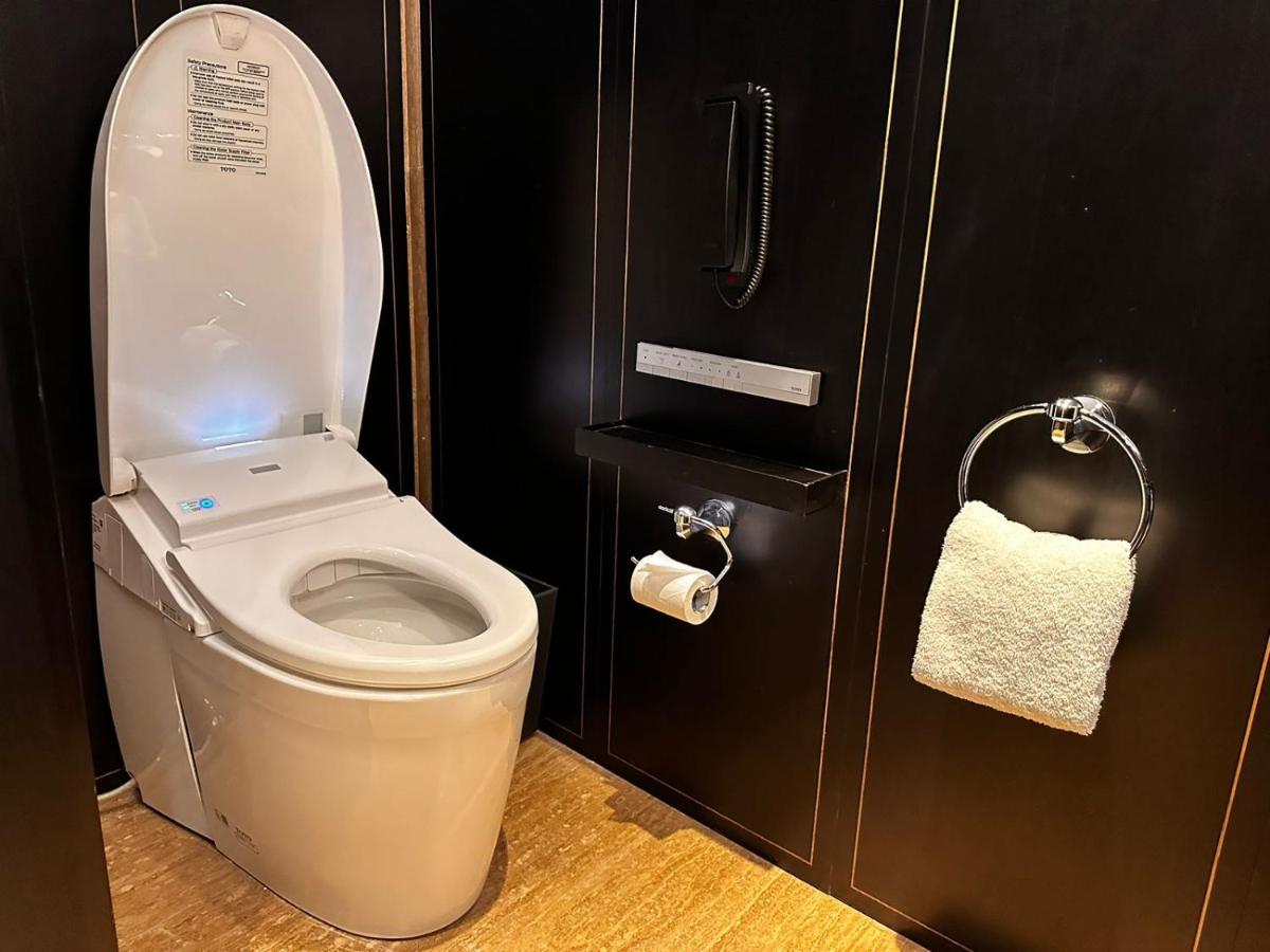 a bathroom with a toilet and a roll of toilet paper at Grand Hyatt Gurgaon in Gurgaon